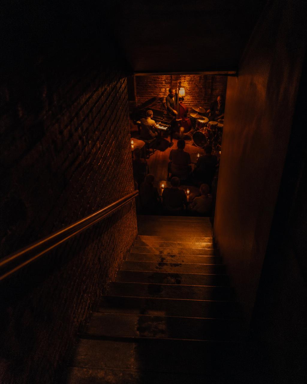 Stairwell down to a warm-lit basement jazz club
